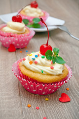 Berry cupcakes on the wooden background