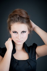 Young attractive fashion model posing on dark background.