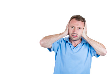 Annoyed man covering ears, having headache from noise