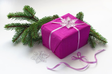Fototapeta na wymiar Розовая подарочная коробка с декоративной снежинкой и ёлкой