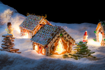 Small gingerbread cottage in winter at night