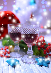 Wine glasses and Christmas decorations on bright background