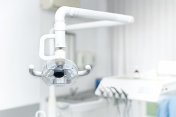Dental light stand next to dental chair and tools in use