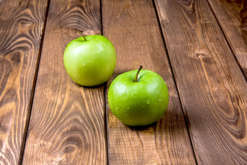Two apples on a wooden background