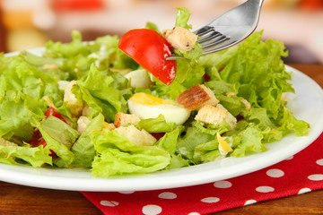 Caesar salad on white plate, on bright background