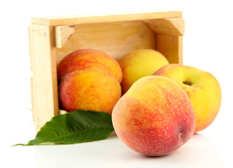 Ripe sweet peaches in wooden crate, isolated on white