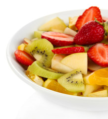 Useful fruit salad of fresh fruits and berries in bowl isolated