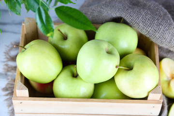 Juicy apples in box on wooden table