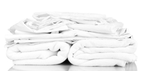 Stack of rumpled bedding sheets isolated on white