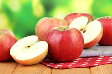 Ripe apples on  wooden table, on bright background