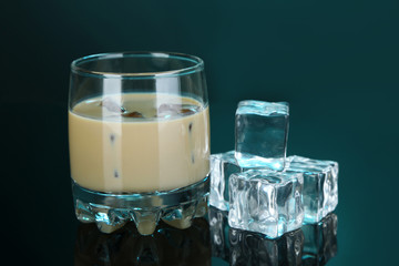 Baileys liqueur in glass on blue background