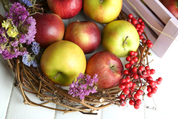 Juicy apples in box on white wooden table