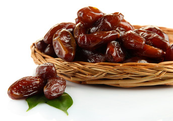 Dried dates on wicker plate isolated on white