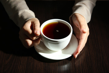 Hands holding mug of hot drink, close-up