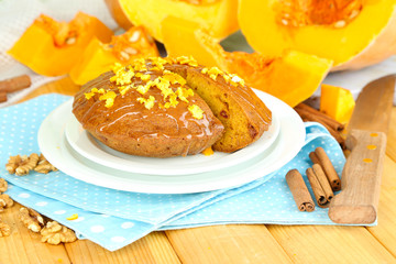 Delicious pumpkin pie on plate on wooden table close-up