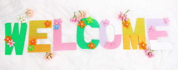 Word Welcome created with brightly colored knitting yard