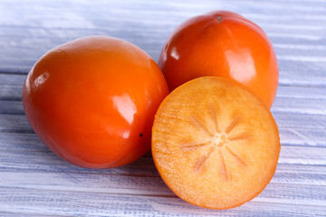 Ripe persimmons on wooden background