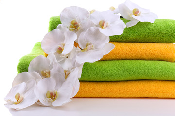 Obraz na płótnie Canvas Colorful towels and orchid flowers, isolated on white