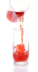 Juice pouring into glass isolated on white