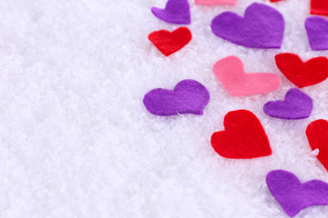 Fototapeta premium Little felt hearts on snowy background