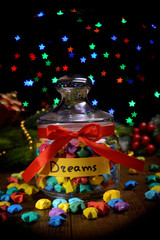 Paper stars with dreams on table on dark background