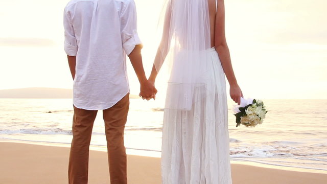 Newly married couple on tropical beach after sunset wedding, Rom