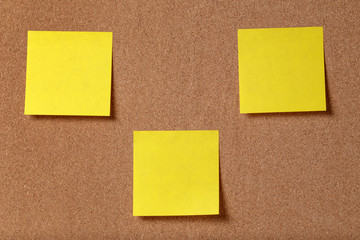 three reminder sticky notes on cork board