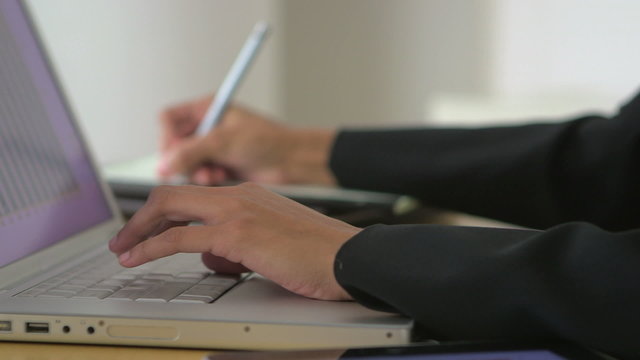Close up of business woman's hands using laptop