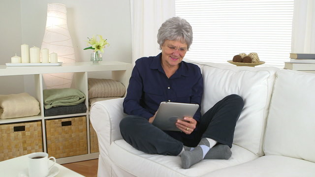 Senior woman using tablet on couch