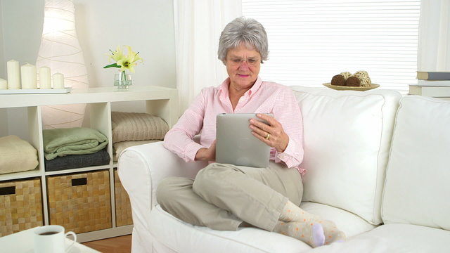 Happy old woman using tablet
