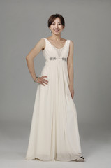 Fototapeta na wymiar beautiful smiling girl in a white wedding dress on a gray