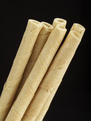 rolled wafers on black background