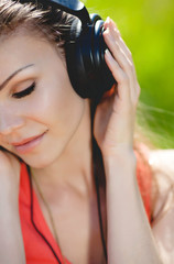 Beautiful young woman listen to music wearing headphones outdoor