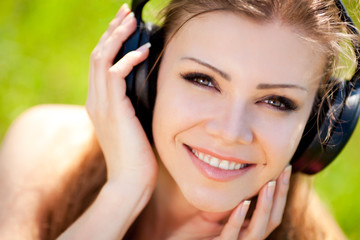 Beautiful young woman listen to music wearing headphones outdoor