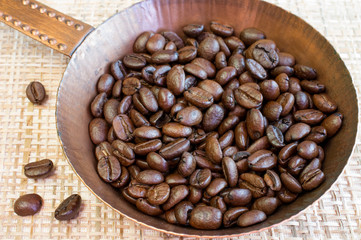 Coffee beans in a copper pan