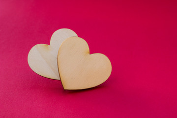 Valentine's day card with two wooden hearts symbol on red surfac