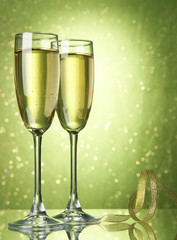 Two glasses of champagne on bright background with lights