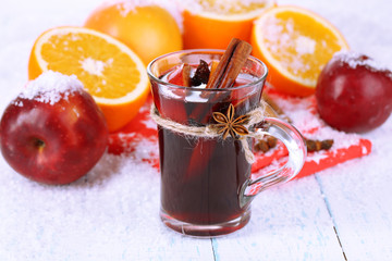 Fragrant mulled wine in glass on snow close-up