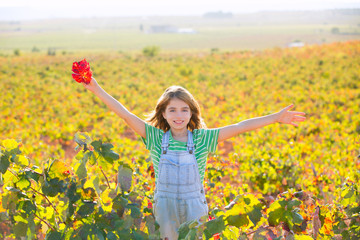 Naklejka na ściany i meble Kid girl in happy autumn vineyard field open arms with red leaf