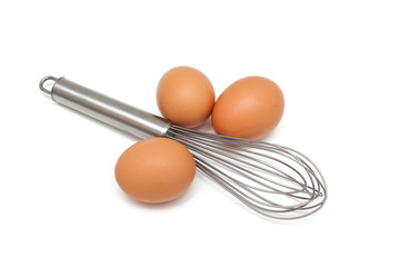 fresh eggs and metallic whisk