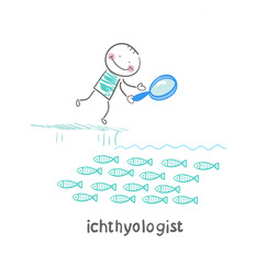 ichthyologist looks at the fish through a magnifying glass