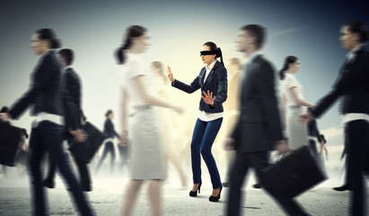 Businesswoman in blindfold among group of people