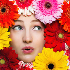 Young girl with flowers around her face. Gerbera daisy flowers