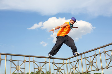 A man stands on a thin fence during breakdancing © Pavel Losevsky