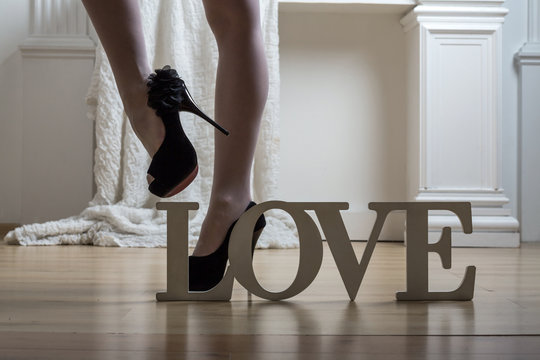 female legs in stockings and shoes and word Love