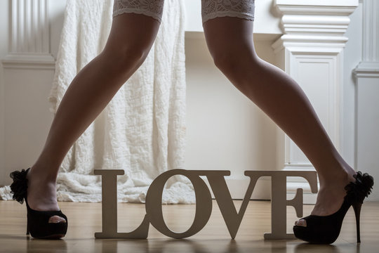 female legs in stockings and shoes and word Love
