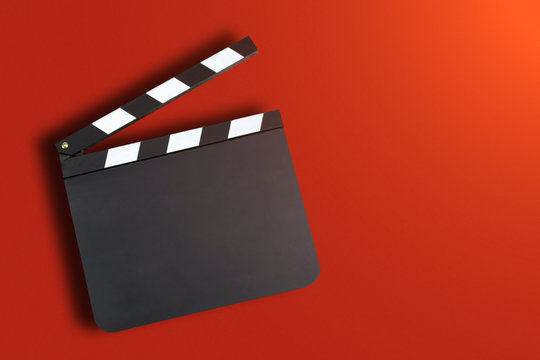 Blank movie production clapper board over red background with co
