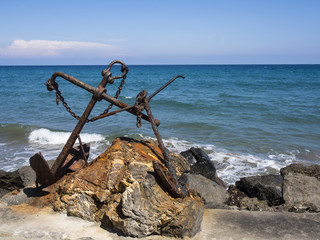 Rusted anchor on seashore