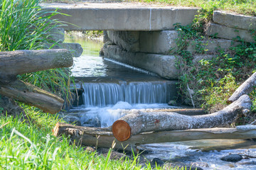 water flowing from a drain pipe into a small river