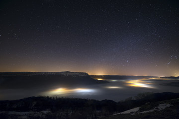 Stars in a foggy night over the valley